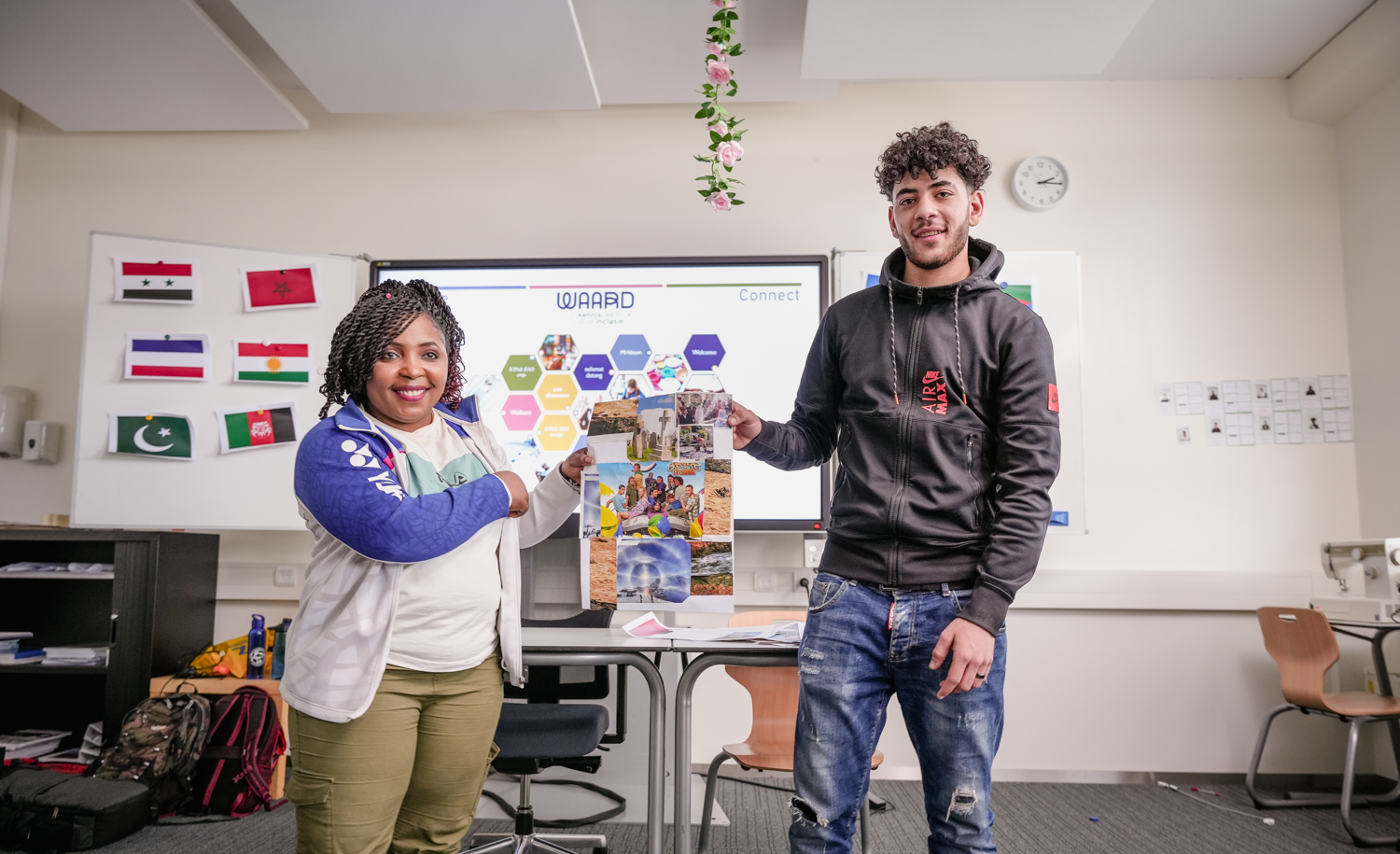 Twee studenten staan voor de klas en presenteren hun werk.